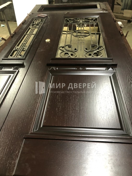 Высокая дверь с художественной ковкой - фото